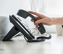 Person nimmt Telefonhörer ab
